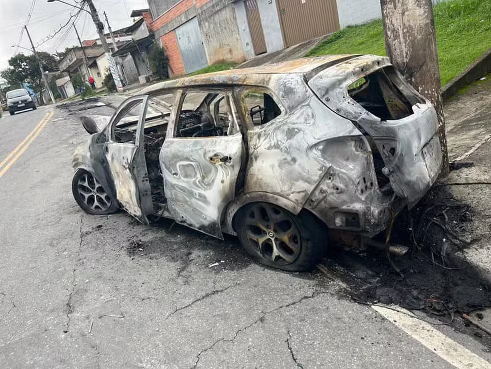 Veículo foi destruído pelo fogo após o acidente no bairro; polícia investiga o paradeiro do condutor que fugiu da cena. (Foto: Reprodução / Rede Alto Tietê TV)